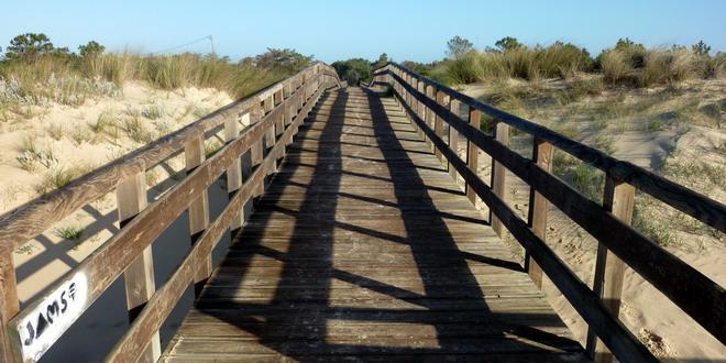 Ein langer Holzsteg führt über die Düne an den Strand von Monte Gordo, Algarve, Portugal